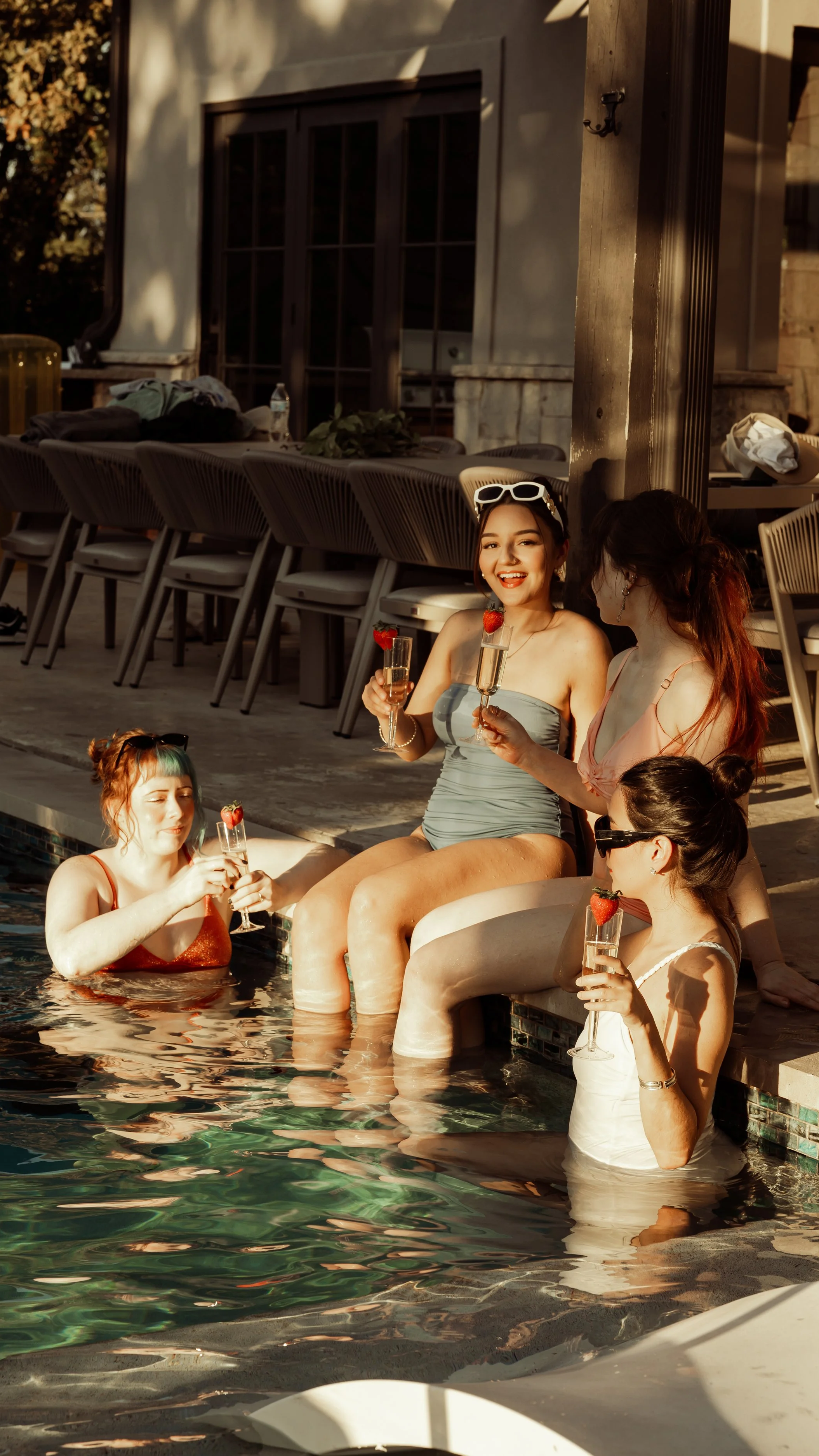 Women enjoying poolside drinks at sunset at The Penrose House